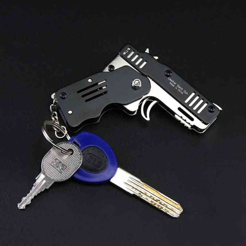 Celý kovový mini lze složit jako hračku s gumovou pistolí na klíčenku