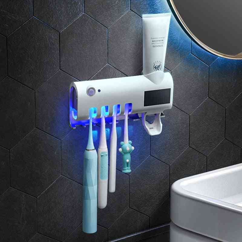 Automatický držák zubního kartáčku na ultrafialové záření se stlačovacím dávkovačem zubní pasty