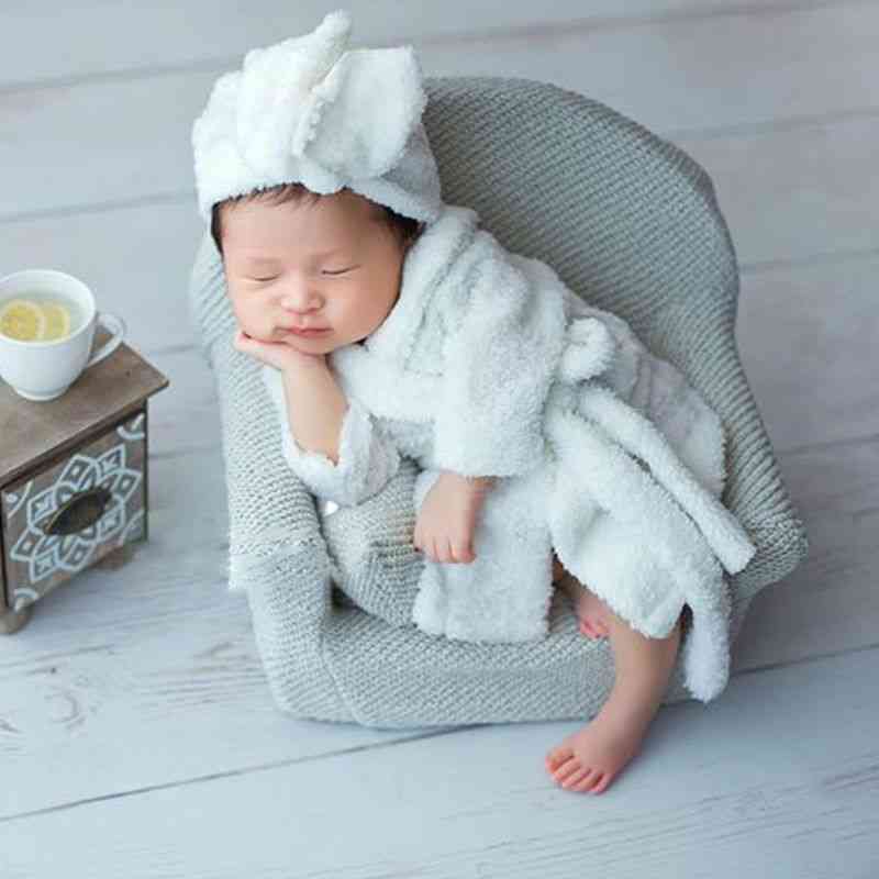 Oggetti di scena per la fotografia del neonato che posano i cuscini della poltrona del mini divano