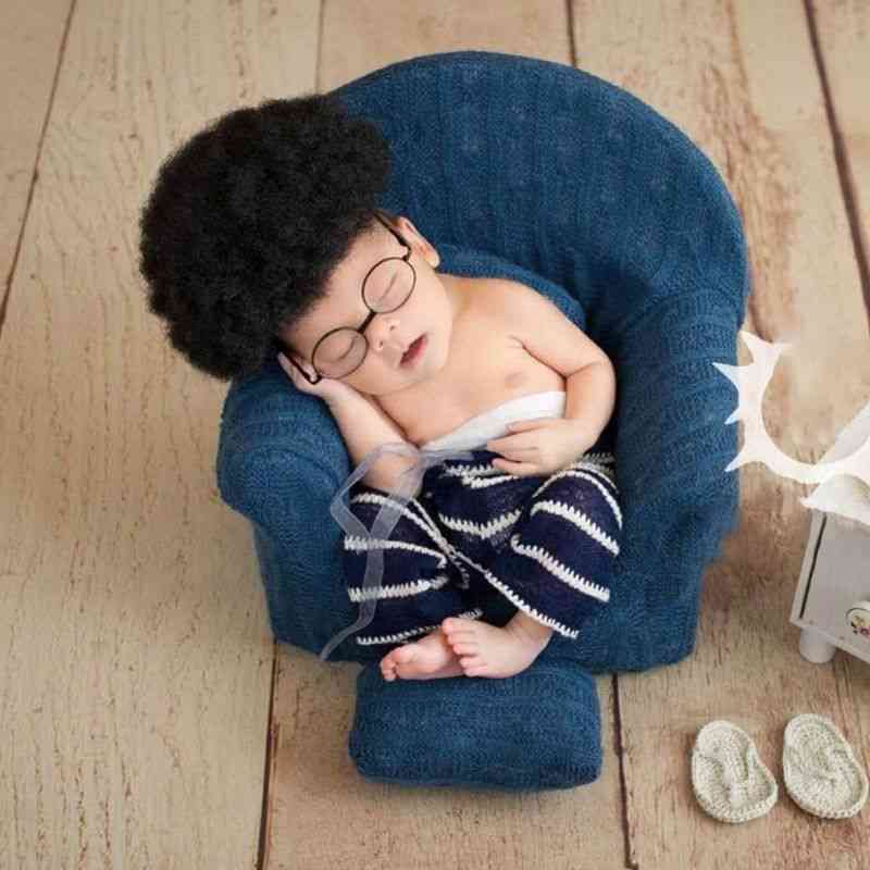 Oggetti di scena per la fotografia del neonato che posano i cuscini della poltrona del mini divano